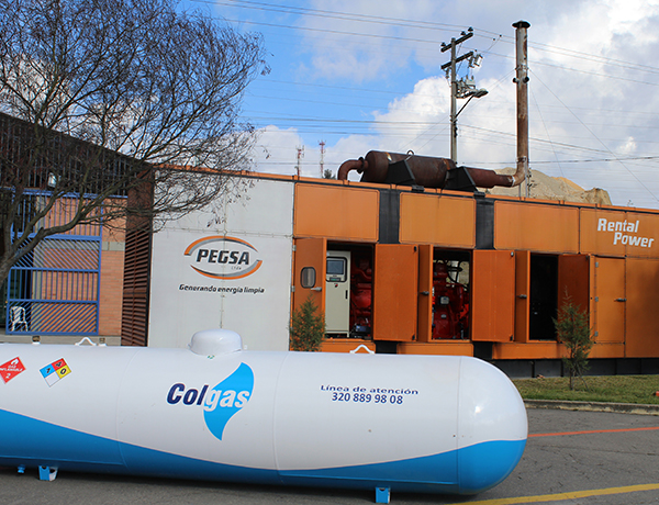 Un edificio color naranja con un cilindro blanco con el logo de Colgas a un lado